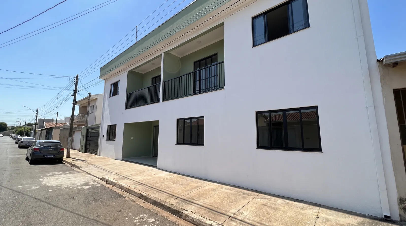 Prédio de dois pavimentos com fachada branca recém-pintada
