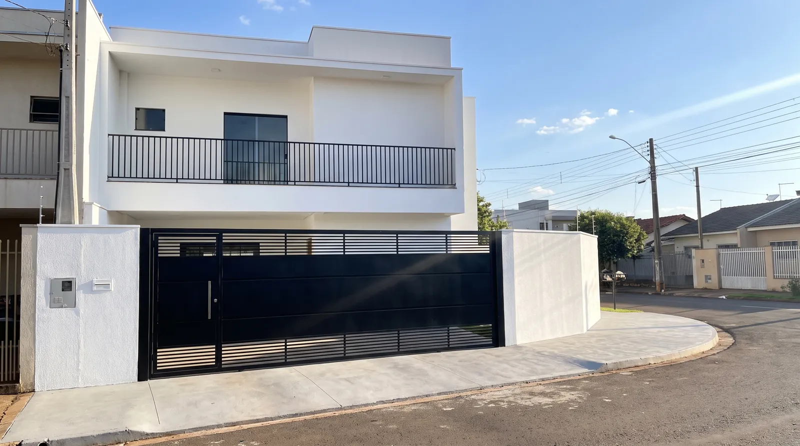 Fachada de sobrado pintada pela Lume, com portão preto e paredes brancas