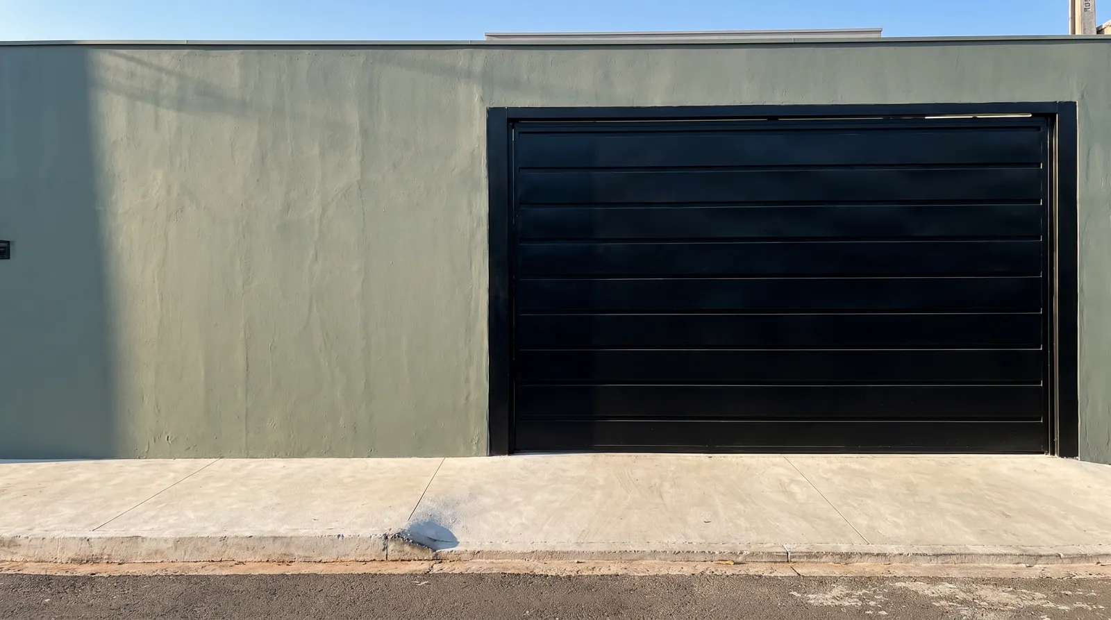 Fachada verde-acinzentada com portão preto